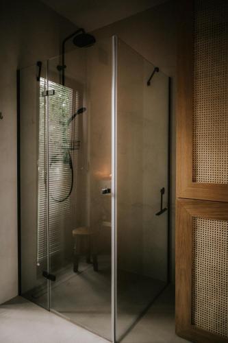 a shower in a bathroom with a glass door at Domek w Lesie in Rozogi