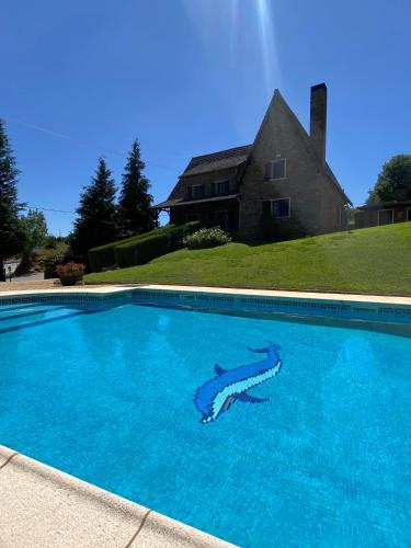 a large blue swimming pool in front of a house at Quinta do Azibo in Podence