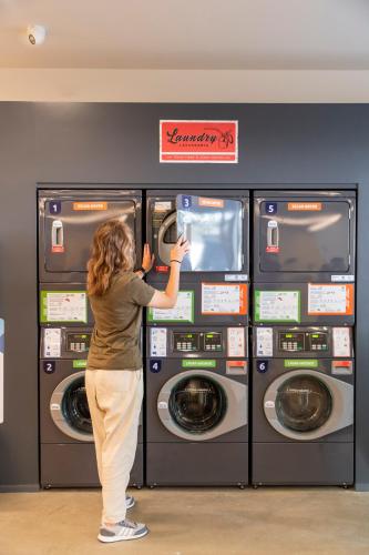 a woman standing in front of a washing machine at WOT Lisbon Patio in Lisbon