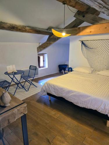 a bedroom with a bed and a table and chairs at L'uzanges in Lussan