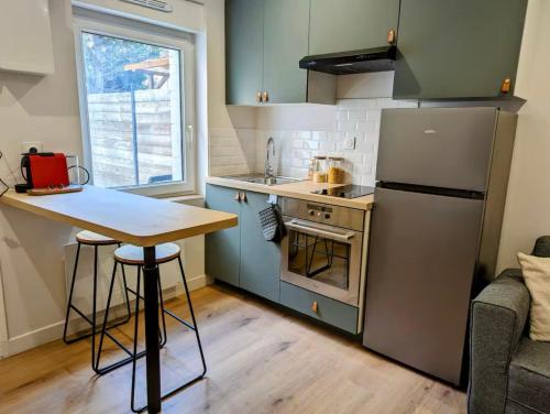 a small kitchen with a table and a refrigerator at Appartement La Parenthèse in Douai