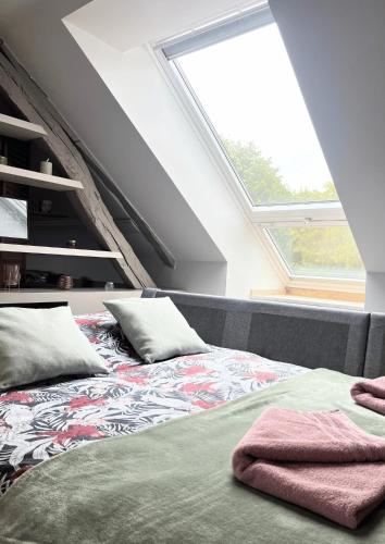 a bedroom with a bed with pillows on it at Maison Menadel in Yvetot
