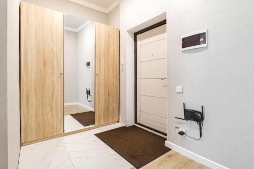 a hallway with a door and a mirror at Цветущий сад in Astana