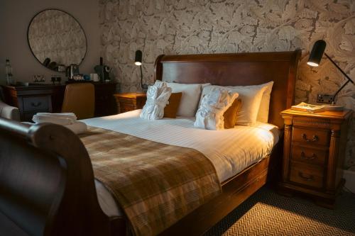 a bedroom with a large bed with white pillows at The Ballachulish Hotel in Glencoe