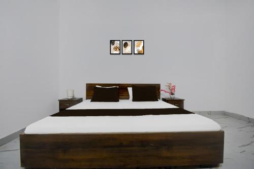a bedroom with a large bed with white sheets at HOTEL O VATIKA & RESORTS in Lucknow