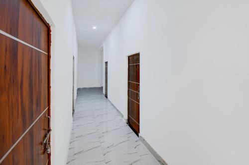 an empty corridor with a door and a hallway with a floor at HOTEL O VATIKA & RESORTS in Lucknow