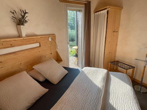 a bedroom with a bed and a large window at Eco Gîte in Payzac