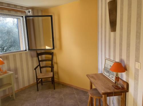 a room with a desk and a chair and a window at Eco Gîte in Payzac