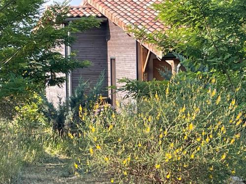 a house with a bunch of flowers in front of it at Eco Gîte in Payzac