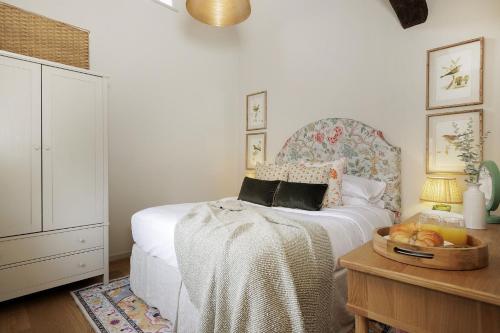 ein Schlafzimmer mit einem Bett und einem Tisch mit einem Tablett Brot in der Unterkunft Little Bird Cottage in Bibury