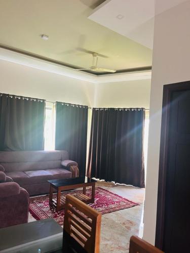 a living room with a couch and a table at Le SAFFRON in Padinjarathara