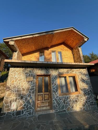 a stone house with a wooden door and windows at Resort Zevs Komovi in Trešnjevik
