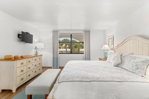a white bedroom with a large bed and a television at Costa Del Sol Resort in Fort Lauderdale