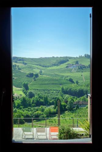 a window with a view of a green field at Foresteria, Winery & Events Destination in Monforte dʼAlba