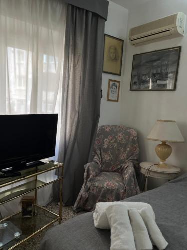 Un dormitorio con una cama y una silla y un televisor. en Stanza con ottima posizione, en Roma