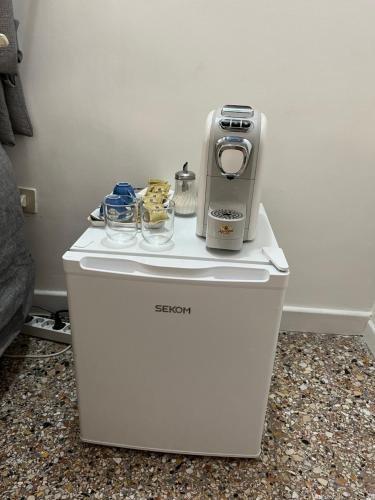 una nevera pequeña con cafetera encima en Stanza con ottima posizione, en Roma