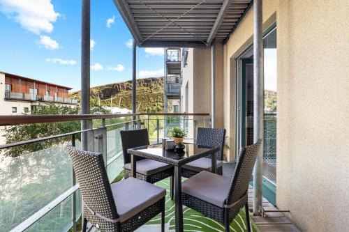 a patio with a table and chairs on a balcony at Park Royal Apartment in Edinburgh