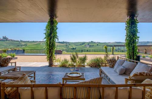 a patio with a couch and chairs and a table at Foresteria, Winery & Events Destination in Monforte dʼAlba