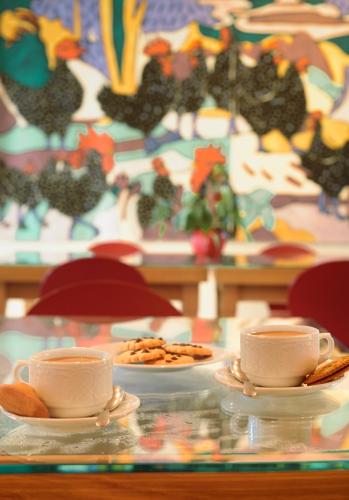 a table with two cups and plates of food at Foresteria, Winery & Events Destination in Monforte dʼAlba