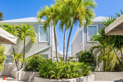 a house with palm trees in front of it at New Casa Caribe by Brightwild- Two-Story Condo Rooftop Pool in Key West