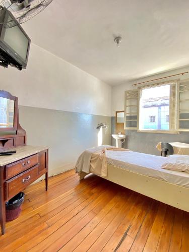 a bedroom with a large bed and a television at Hotel Avenida Bauru in Bauru