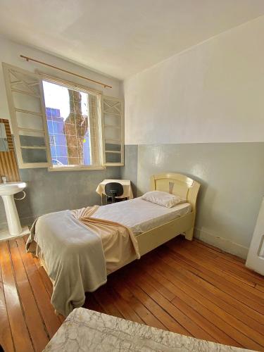 a small bedroom with a bed and a window at Hotel Avenida Bauru in Bauru