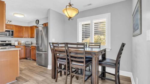 a kitchen with a table and chairs and a refrigerator at Relaxing Cherry Grove Beach House with Balcony Family Fun in Myrtle Beach