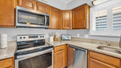 a kitchen with wooden cabinets and a stainless steel appliance at Relaxing Cherry Grove Beach House with Balcony Family Fun in Myrtle Beach