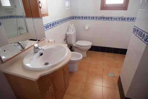 a bathroom with a sink and a toilet at Complejo Bellavista Residencial in Pego