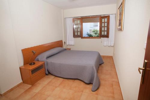 a small bedroom with a bed and a window at Complejo Bellavista Residencial in Pego