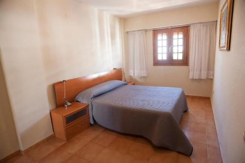 a small bedroom with a bed and a window at Complejo Bellavista Residencial in Pego