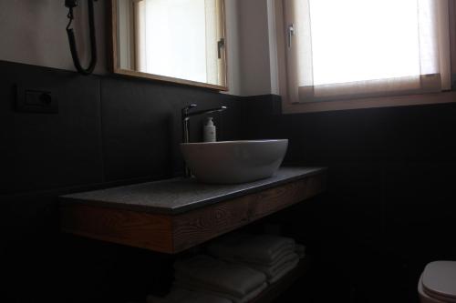 a bathroom with a sink and two windows at Oltre Alpine Hotel in Bormio