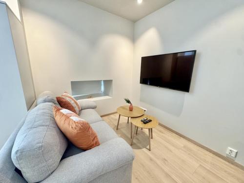 a living room with a couch and a flat screen tv at Chic and Modern Studio - Central in Oslo