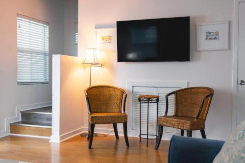 a living room with two chairs and a flat screen tv at New Casa Caribe by Brightwild- Two-Story Condo Rooftop Pool in Key West