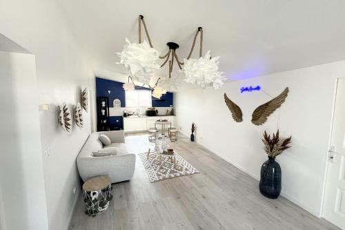 a living room with white walls and a gray couch at The Amantis suite XXL Bath and Sauna in Mauguio in Mauguio