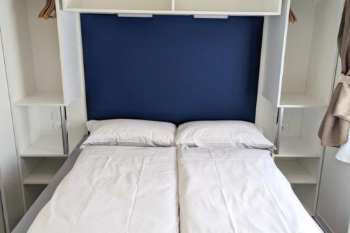 a bed with two pillows in a closet at Mobile Home on Lago Maggiore - Direct Beach Access M3 in Maccagno con Pino e Veddasca