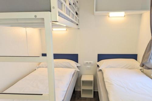 two beds in a room with a bunk bed at Mobile Home on Lago Maggiore - Direct Beach Access M3 in Maccagno con Pino e Veddasca