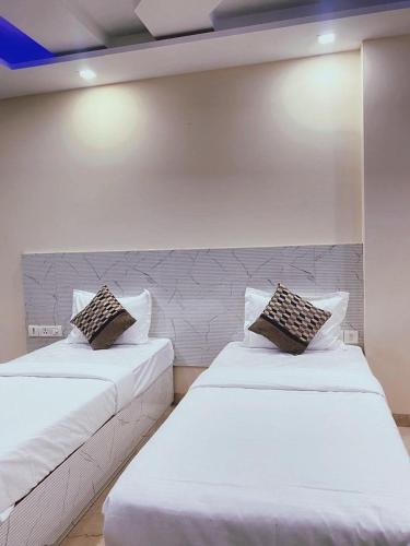 two beds sitting next to each other in a room at Cassava Stay in New Delhi