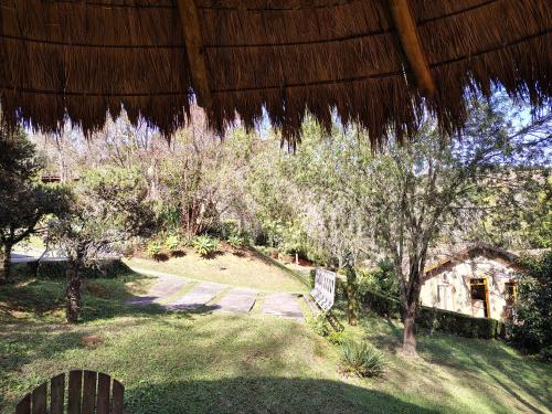 a view of a garden with trees and a building at Pousada dos Pássaros in Santo Antônio do Pinhal