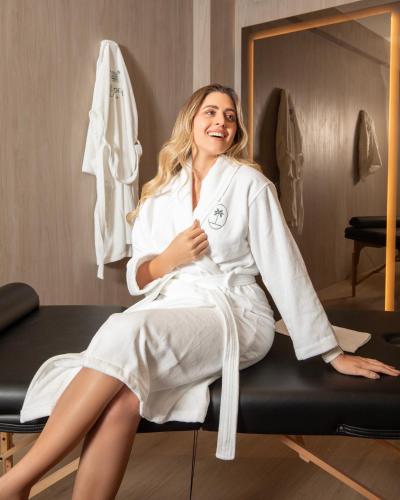 a woman sitting on a bed in a dressing room at La Residence Panamá in Panama City