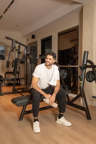 a man sitting on a bench in a gym at La Residence Panamá in Panama City