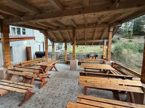 a patio with wooden tables and a grill at Resort Zevs Komovi in Trešnjevik