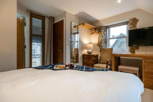 una camera da letto con un letto, una scrivania e una televisione di Evenlode Cottage a Stow on the Wold