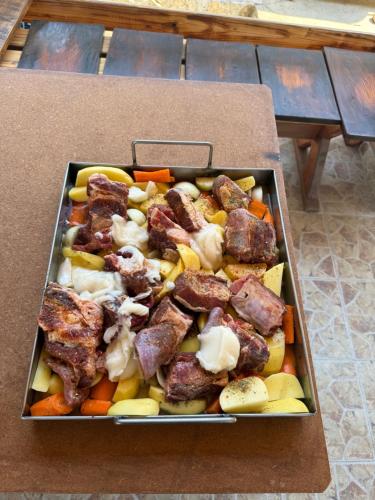 a tray of food with meat and vegetables on a table at Resort Zevs Komovi in Trešnjevik