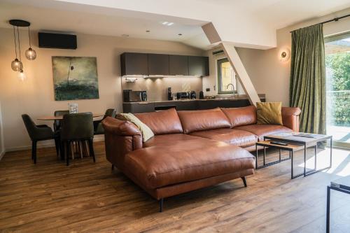 a living room with a leather couch and a table at La Perle de Domme in Sarlat-la-Canéda