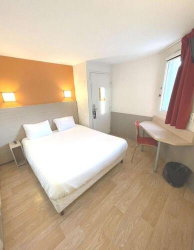a bedroom with a large white bed and a desk at Première Classe Toulouse Nord - L'Union in LʼUnion