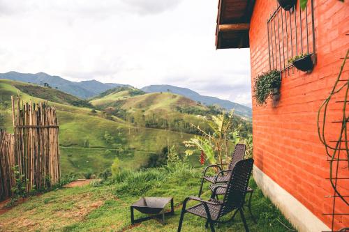 two chairs sitting on the side of a building overlooking a valley at Sítio Passarim in São Francisco Xavier