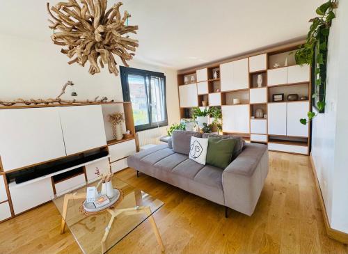 a living room with a couch and a chandelier at Maison au calme et en ville in Meythet