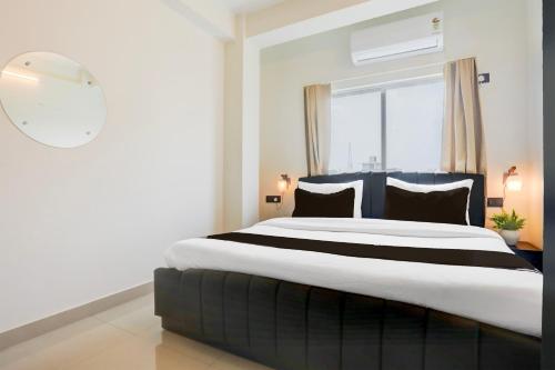 a bedroom with a large bed with a window at Hotel O AAGAMAN HOTEL & RESTAURANT in Begusarai
