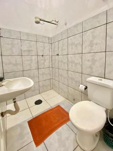a bathroom with a toilet and a sink at Hotel Avenida Bauru in Bauru